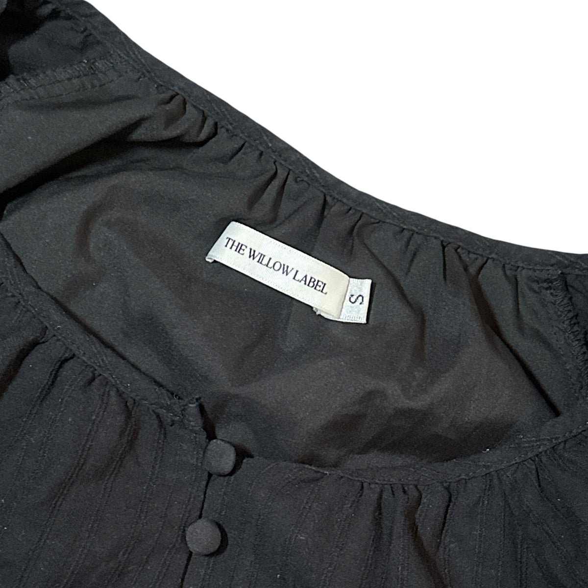 Gemstoresg black short sleeve blouse by The Willow Label featuring a gathered neckline and fabric-covered buttons.